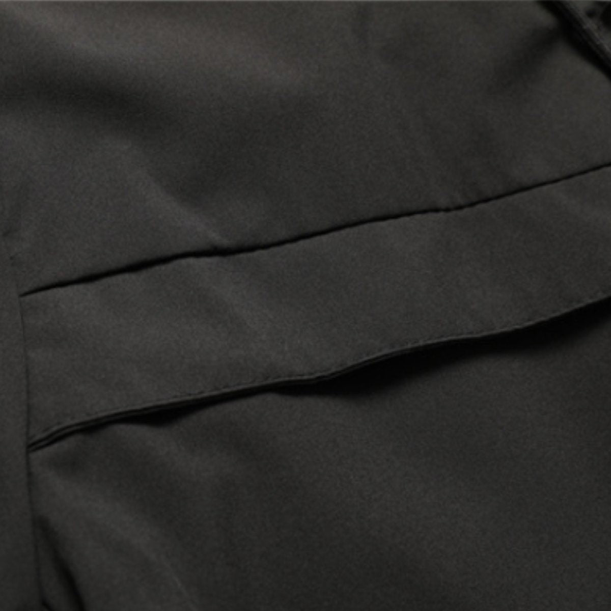 Close-up of black waterproof fabric showing seam and pocket stitching