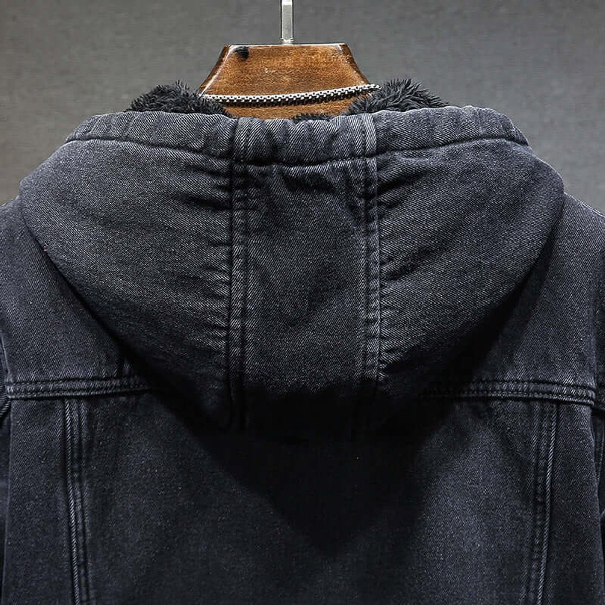 Close-up of fleece-lined hood on black denim jacket with elastic trim