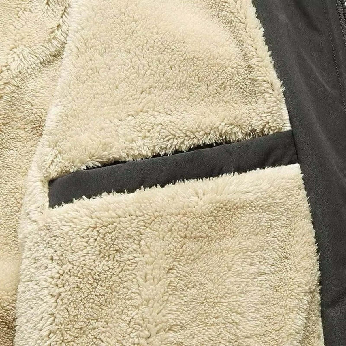 Close-up of cream sherpa fleece lining and inner zip pocket detail