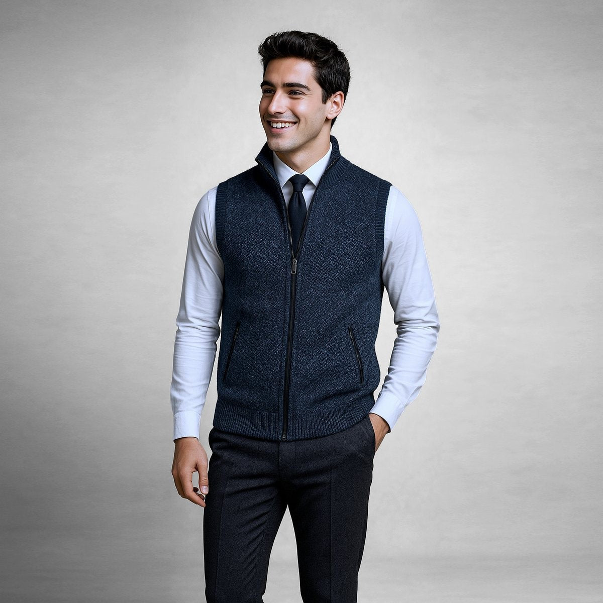 Navy knitted sleeveless zip cardigan layered over shirt and dark trousers