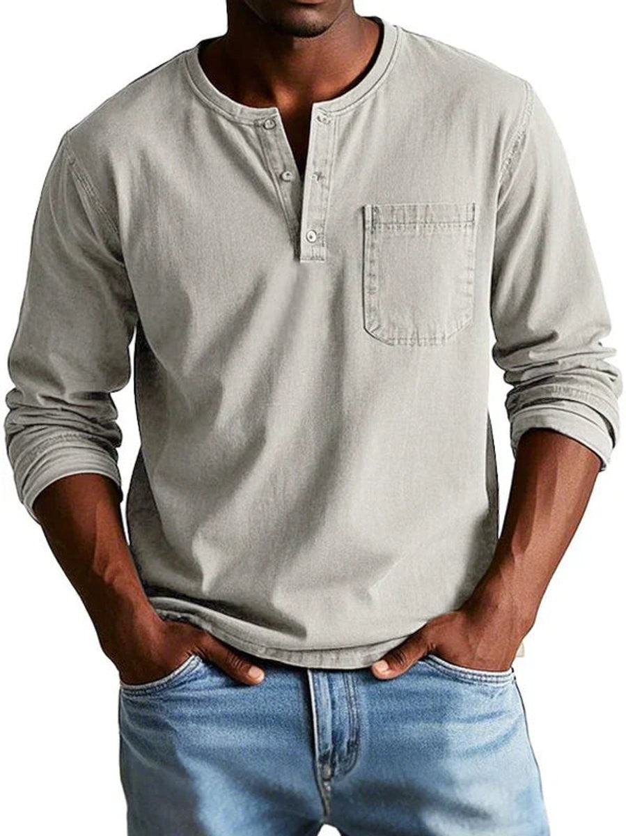 Light grey Henley shirt showing button placket and stitched pocket detail