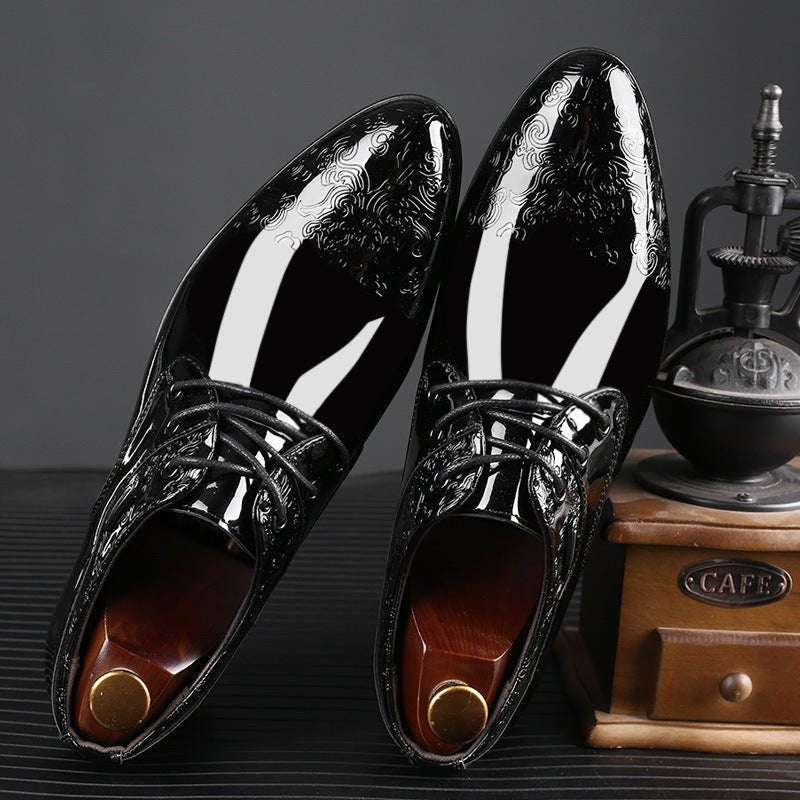 Pair of embossed patent leather formal shoes displayed with shoe trees