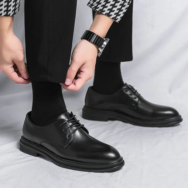 Man adjusting trousers whilst wearing black leather lace-up Derby shoes