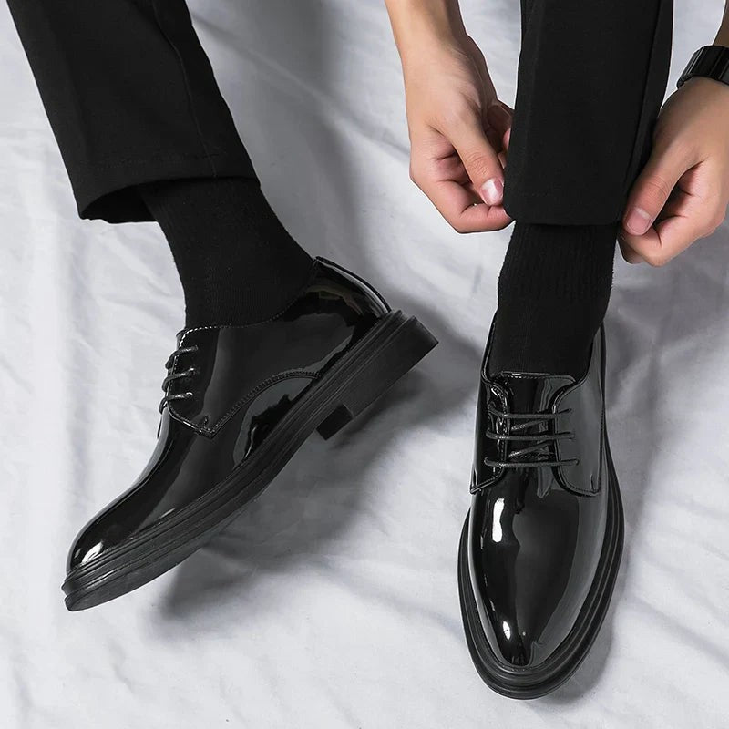 Man wearing pair of glossy black patent leather Derby shoes