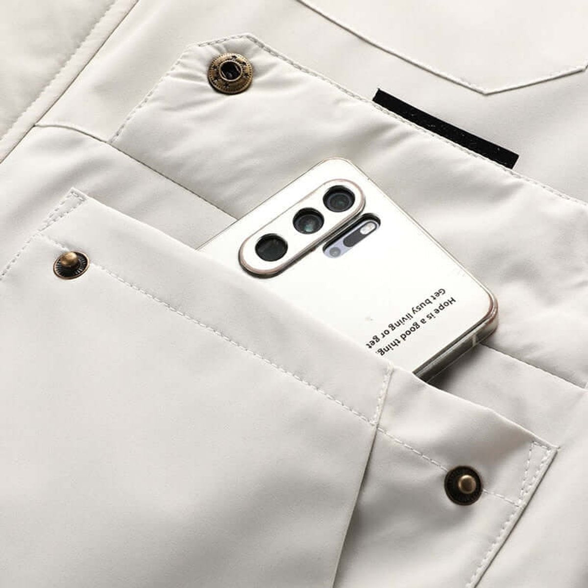 Chest pocket detail showing snap buttons and mobile phone stored inside