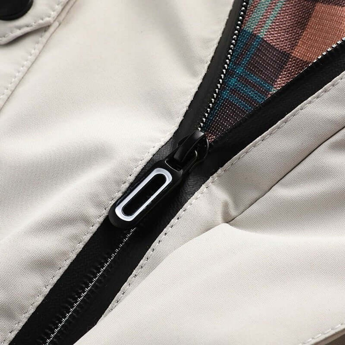 Close-up of front zip with tartan lining peeking through jacket opening