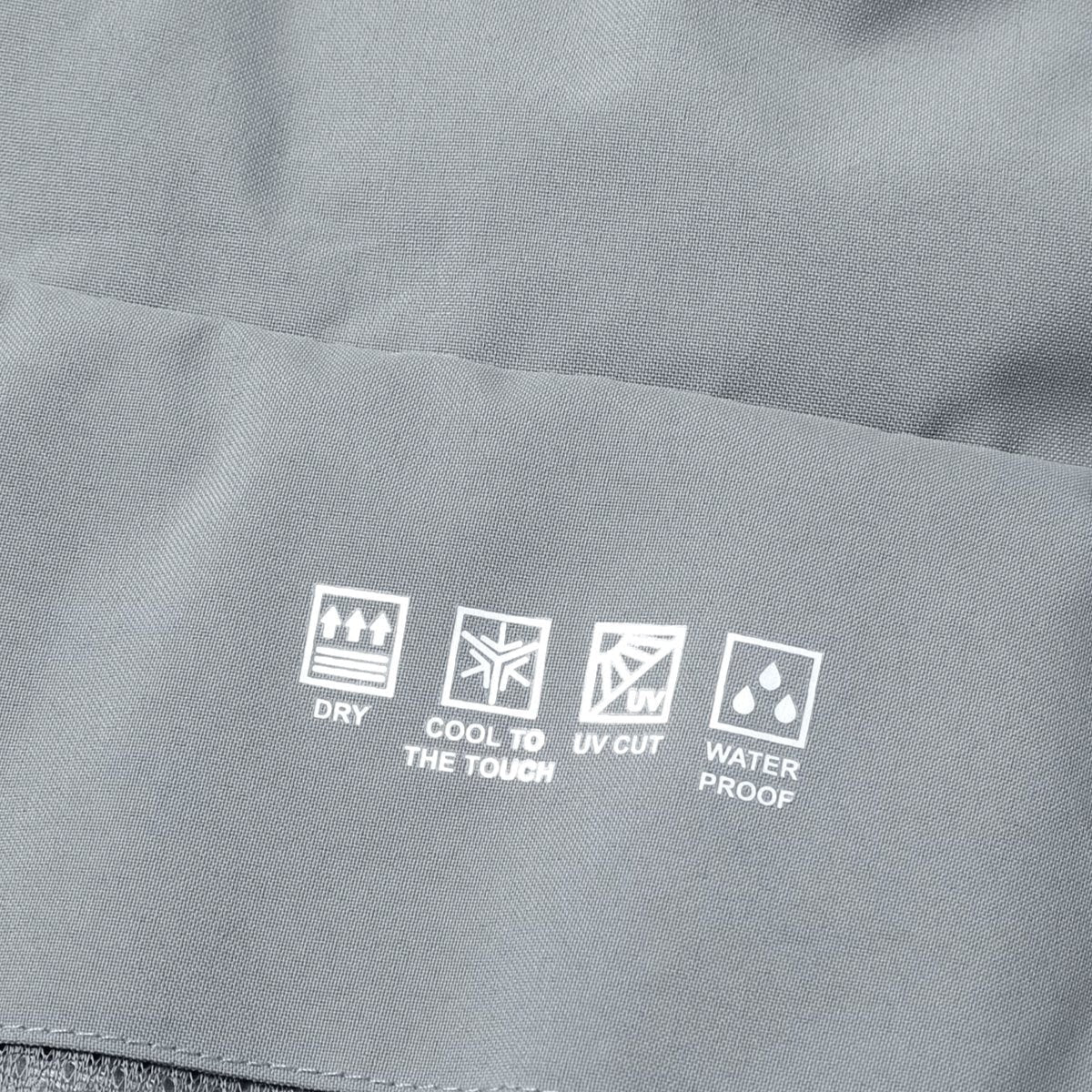 Close-up of grey jacket fabric showing waterproof care icons