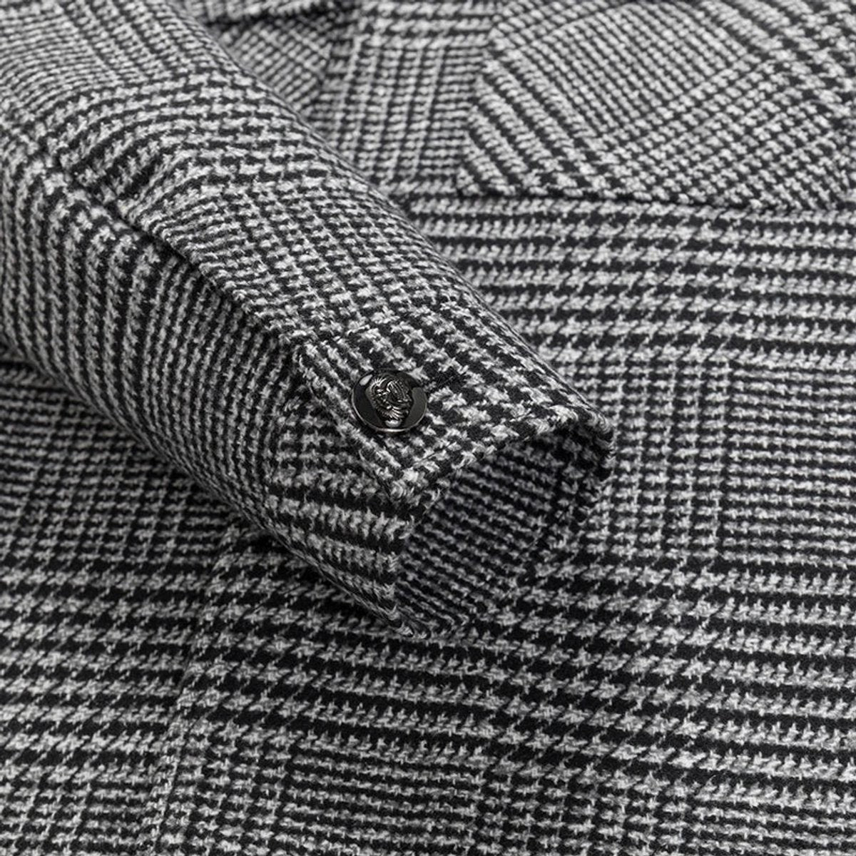 Close-up of cuff button and houndstooth weave detail on wool-blend jacket