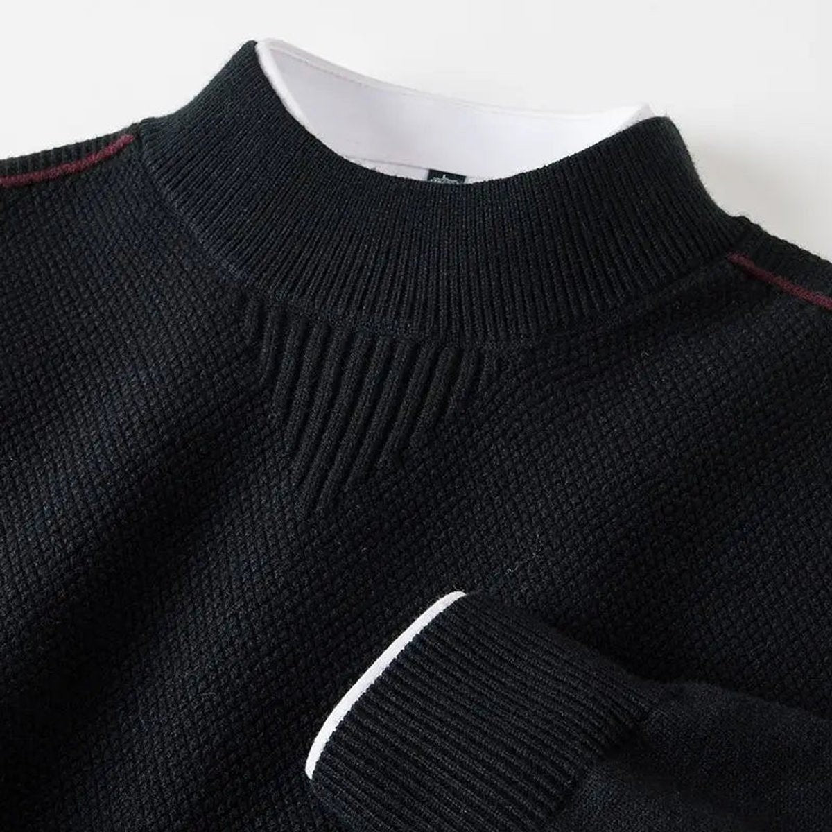 Black mock-neck jumper with subtle burgundy stitching and ribbed collar