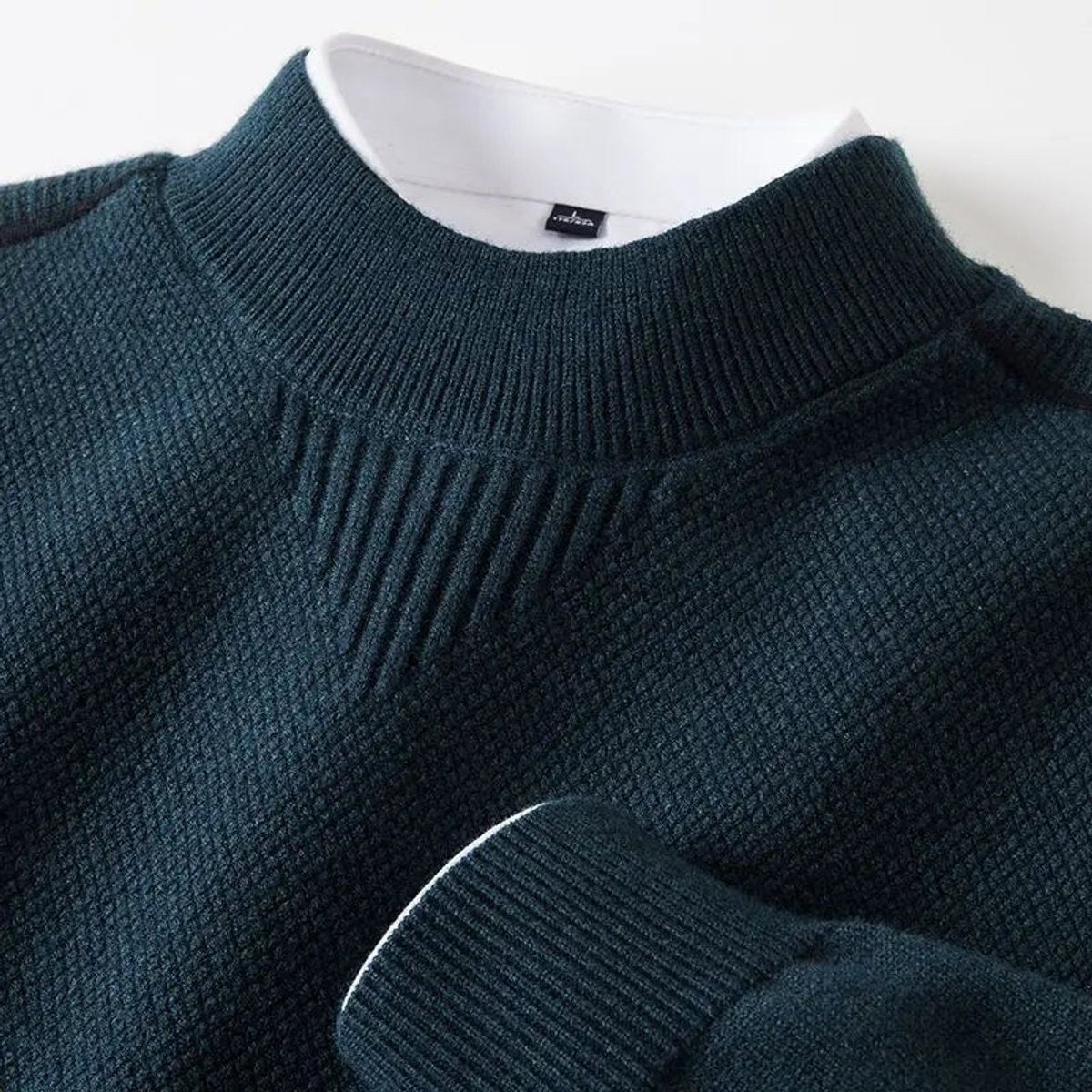 Dark teal mock-neck pullover showing waffle-knit pattern and ribbed trim