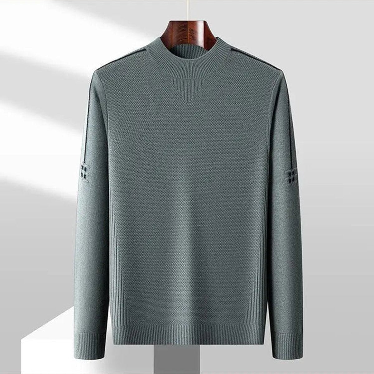 Grey-green jacquard-knit jumper displayed on hanger, front view with mock neck