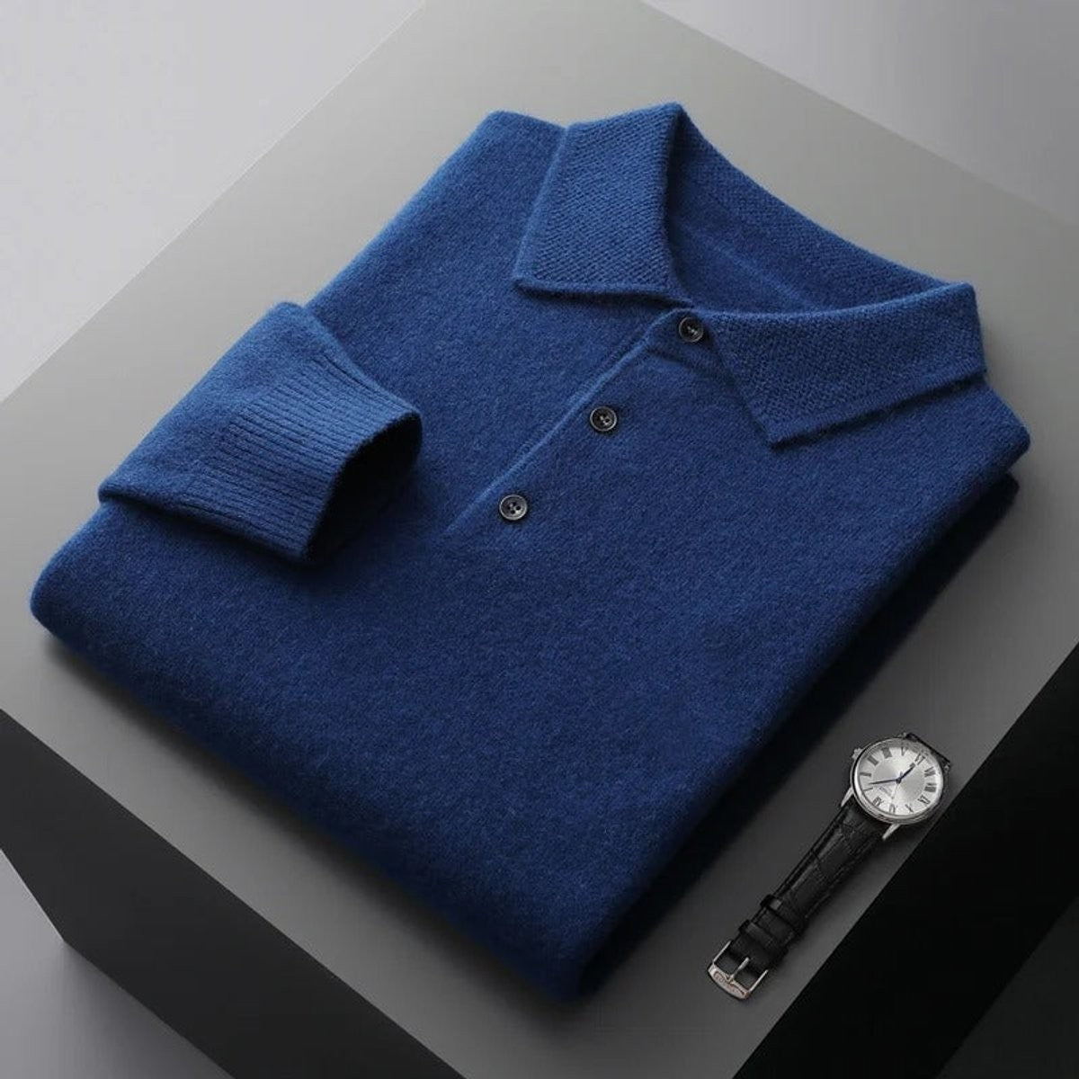 Folded blue knitted polo jumper with ribbed cuffs and button placket