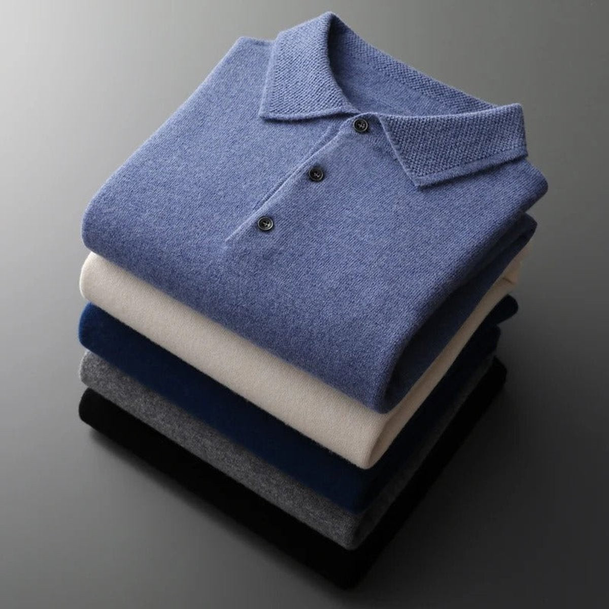 Stack of folded knitted polo jumpers in assorted colourways