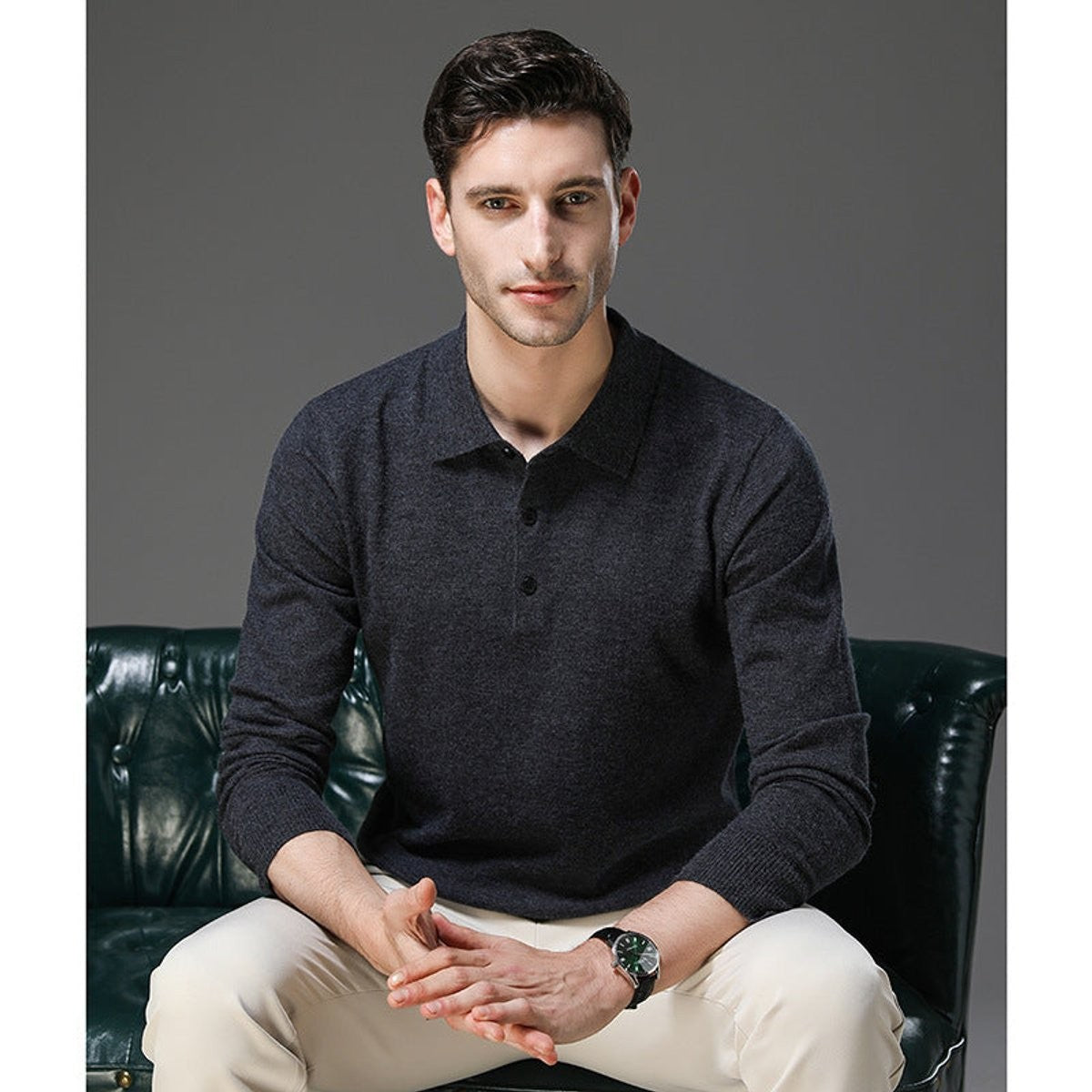 Man seated wearing charcoal knitted polo jumper with button placket