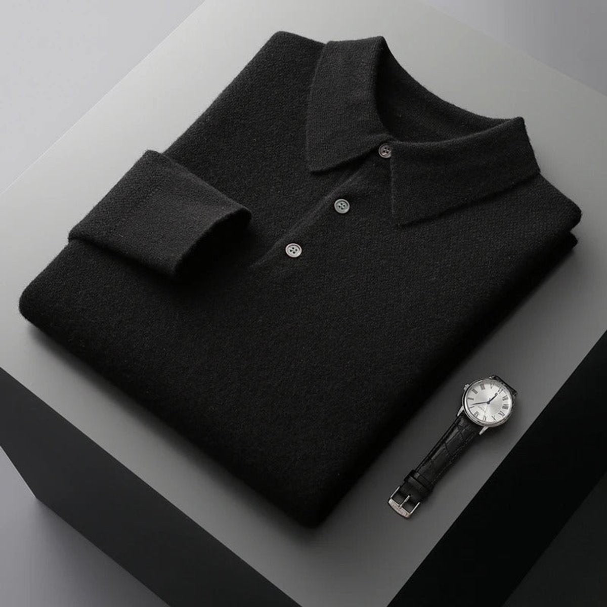 Black knitted polo jumper folded with ribbed sleeves and collar