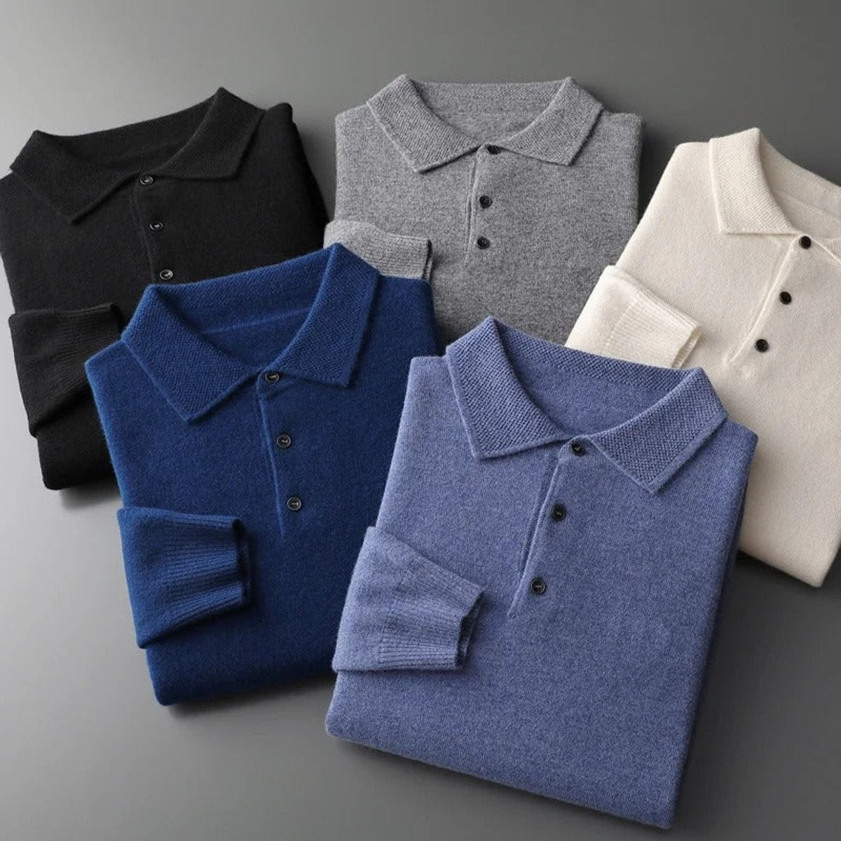 Four folded knitted polo jumpers in blue, grey, cream and black shades