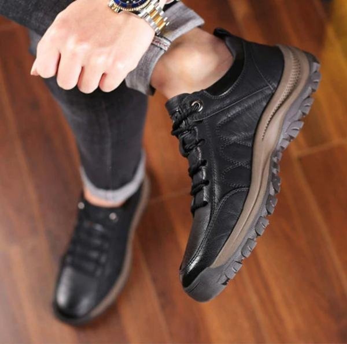 Man wearing black leather lace-up casual shoes with textured outsole