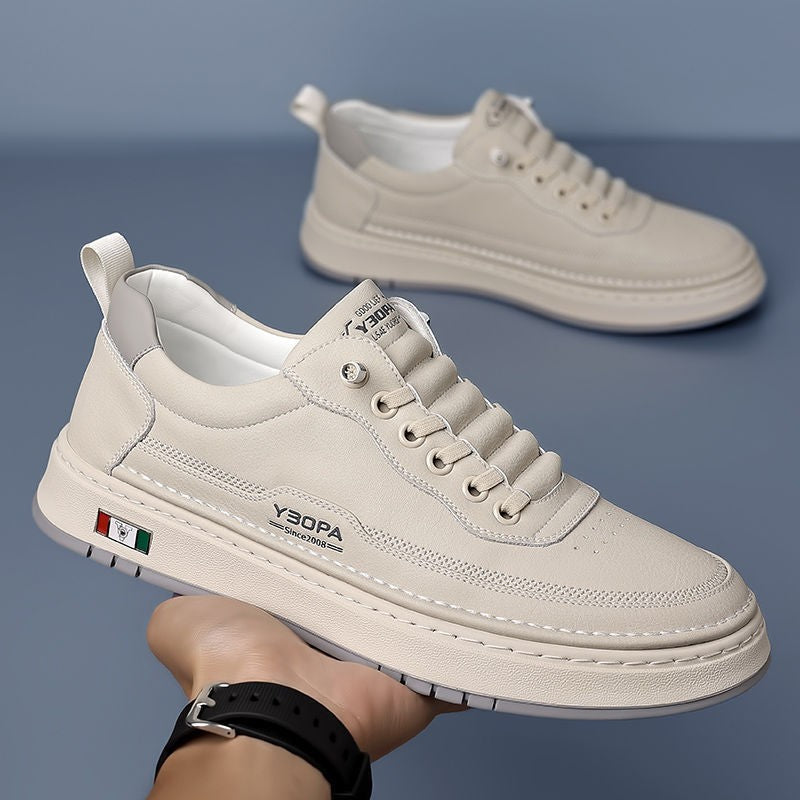 Cream leather trainers paired together against grey backdrop