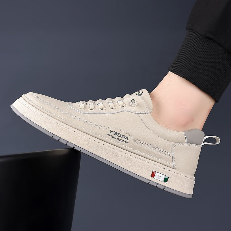 Cream leather trainer modelled on foot with dark trousers