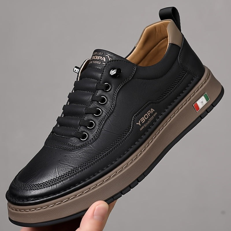 Black leather trainer with tan sole, shown as matching pair