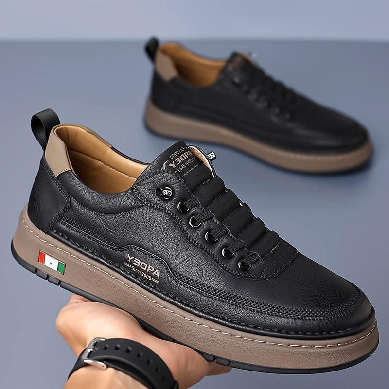 Black leather trainer angled to display lace and sole detail