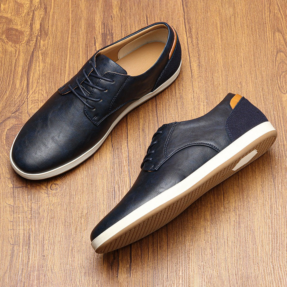 Navy leather lace-up trainers with suede heel accent on wooden backdrop