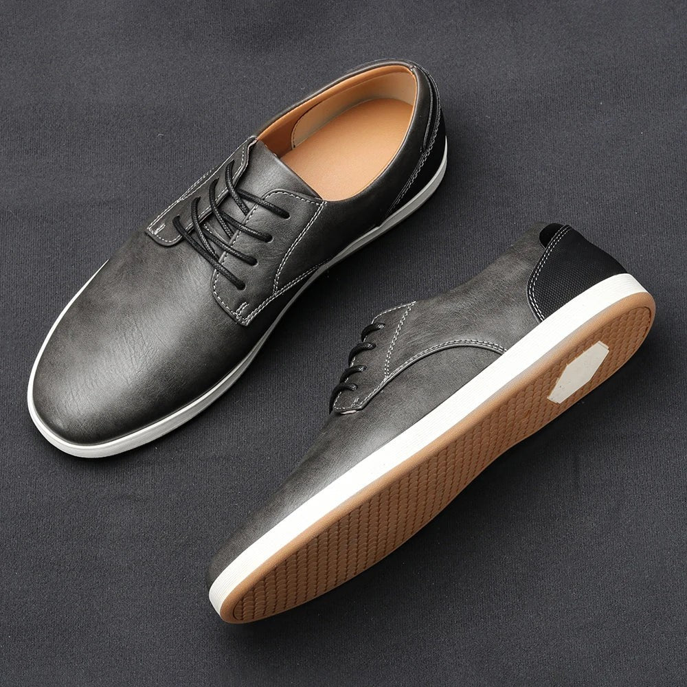Charcoal grey leather lace-up trainers with white rubber sole and tan lining