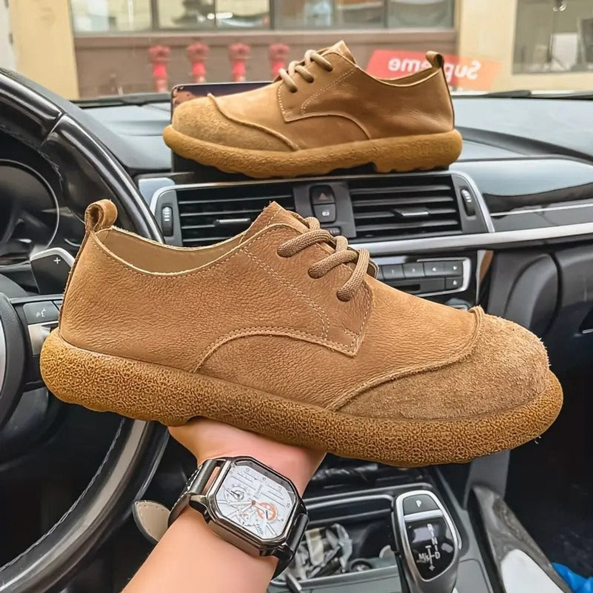 Light brown leather casual shoes held up showing textured sole