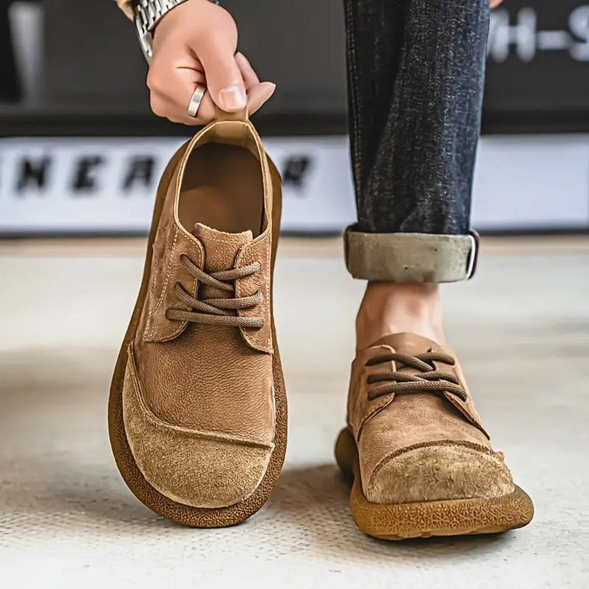 Tan leather lace-up shoe modelled on foot with suede toe detail
