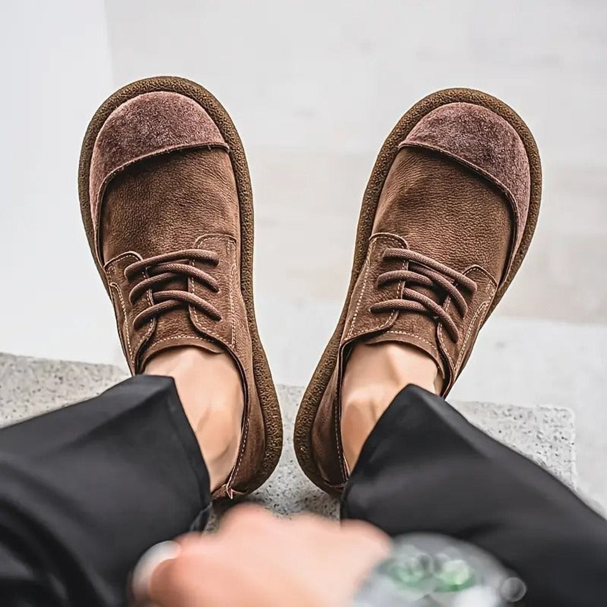 Brown leather lace-up shoes shown from above with wavy stitching