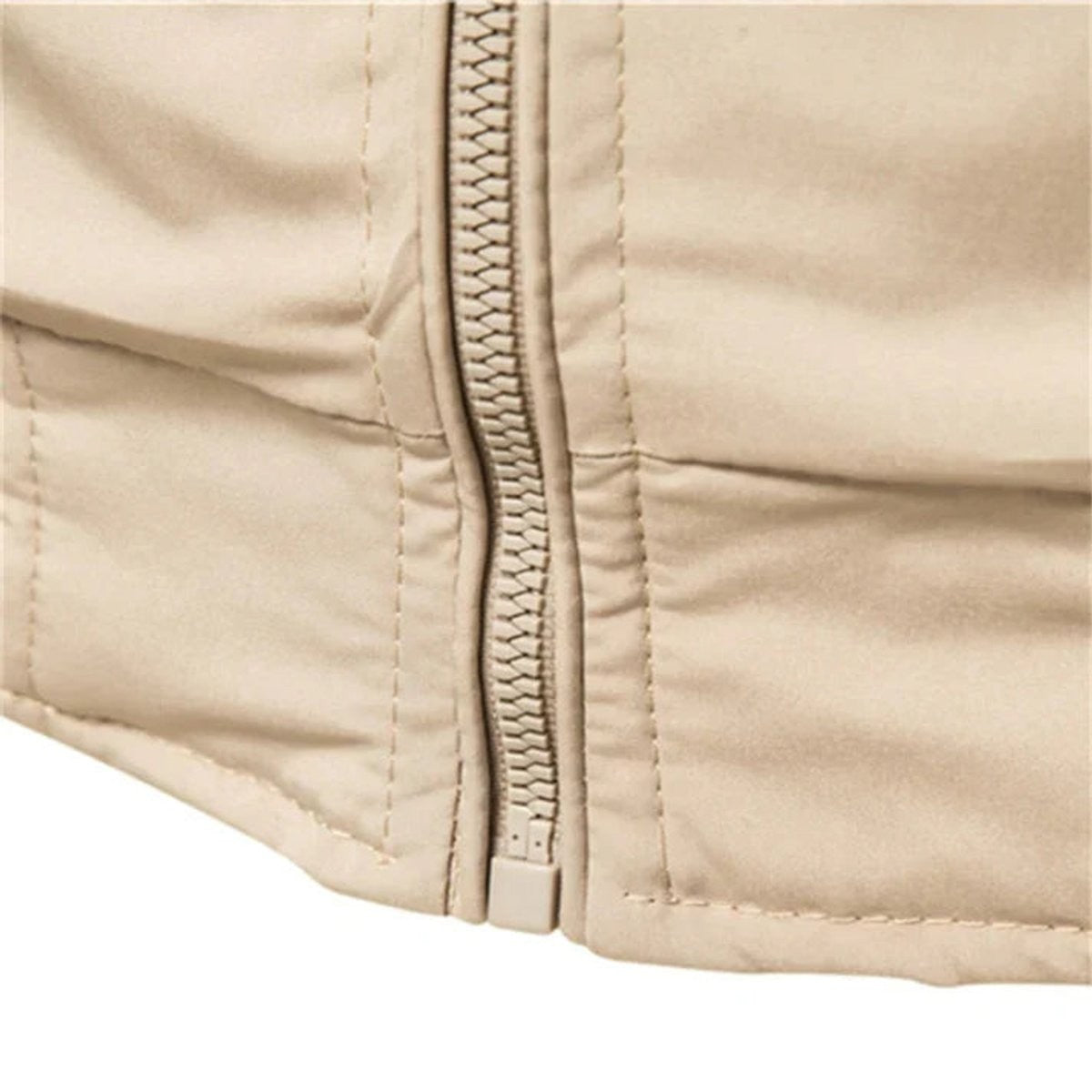 Close-up of beige bomber jacket zip fastening and stitched hem