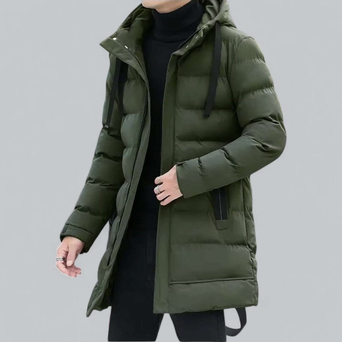 Black longline quilted parka worn over black polo neck