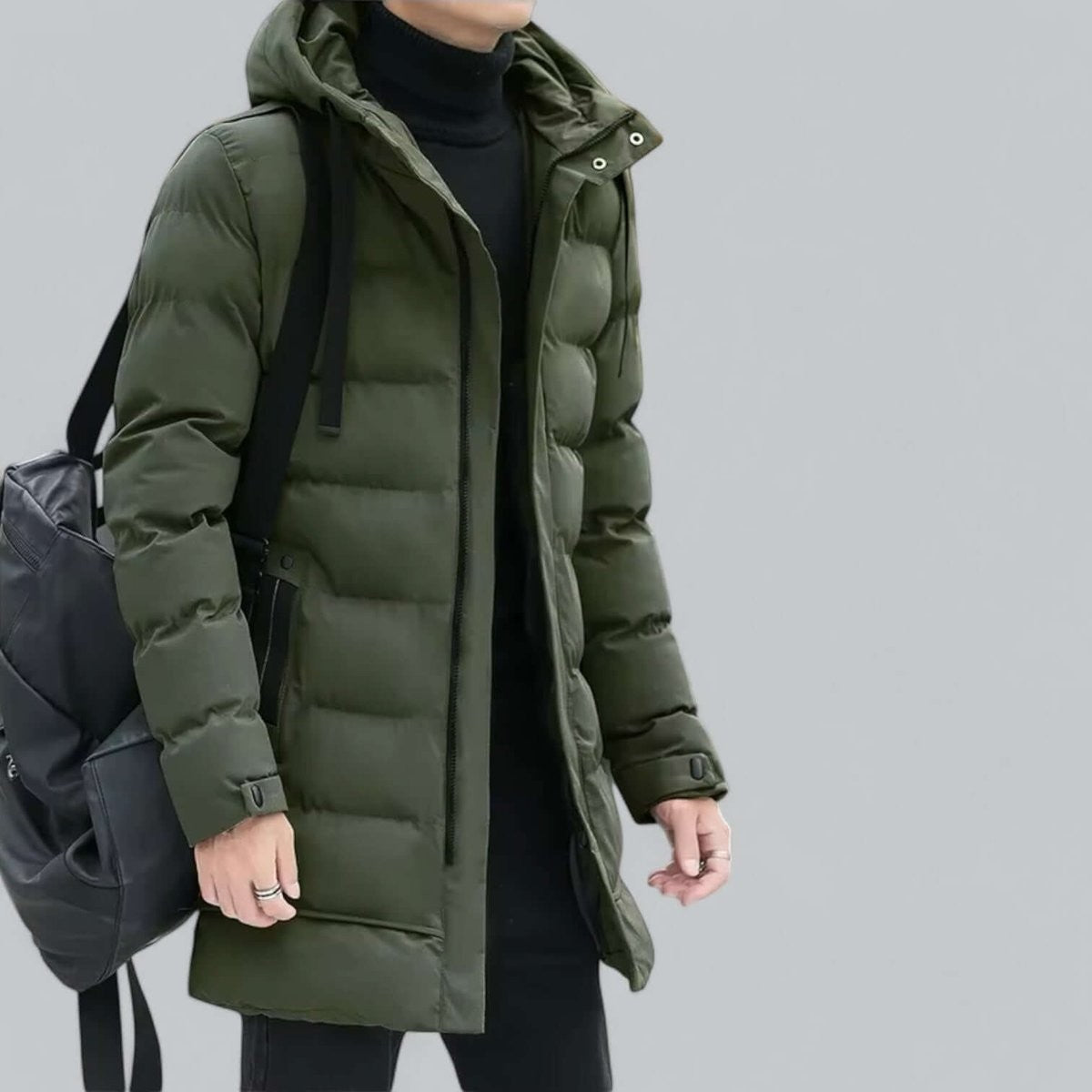 Khaki green longline puffer parka worn with black backpack