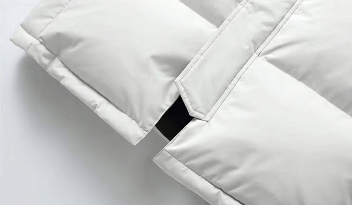 Close-up of white quilted parka cuff showing concealed pocket detail
