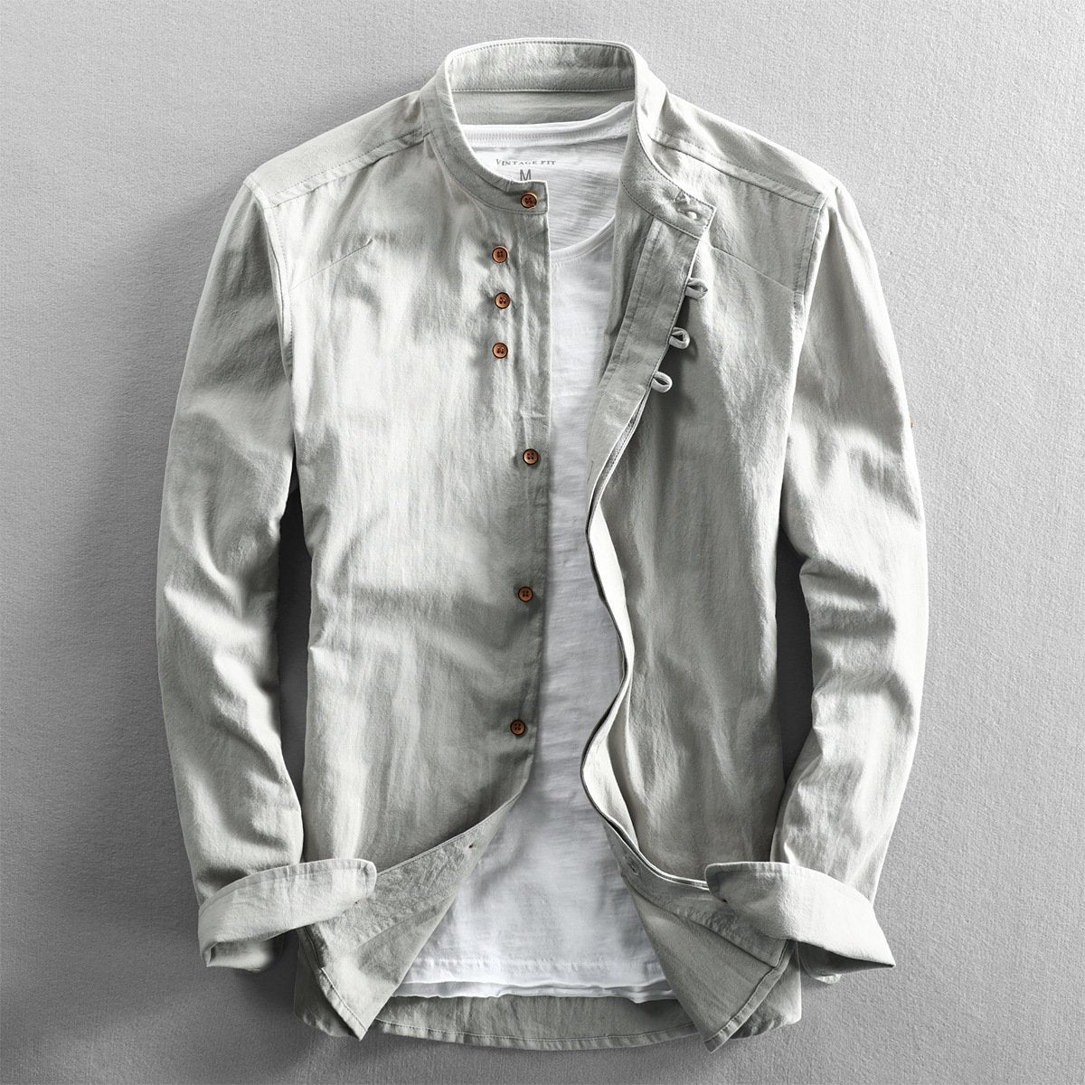 Sage green linen shirt featuring stand collar and roll-up sleeve tabs