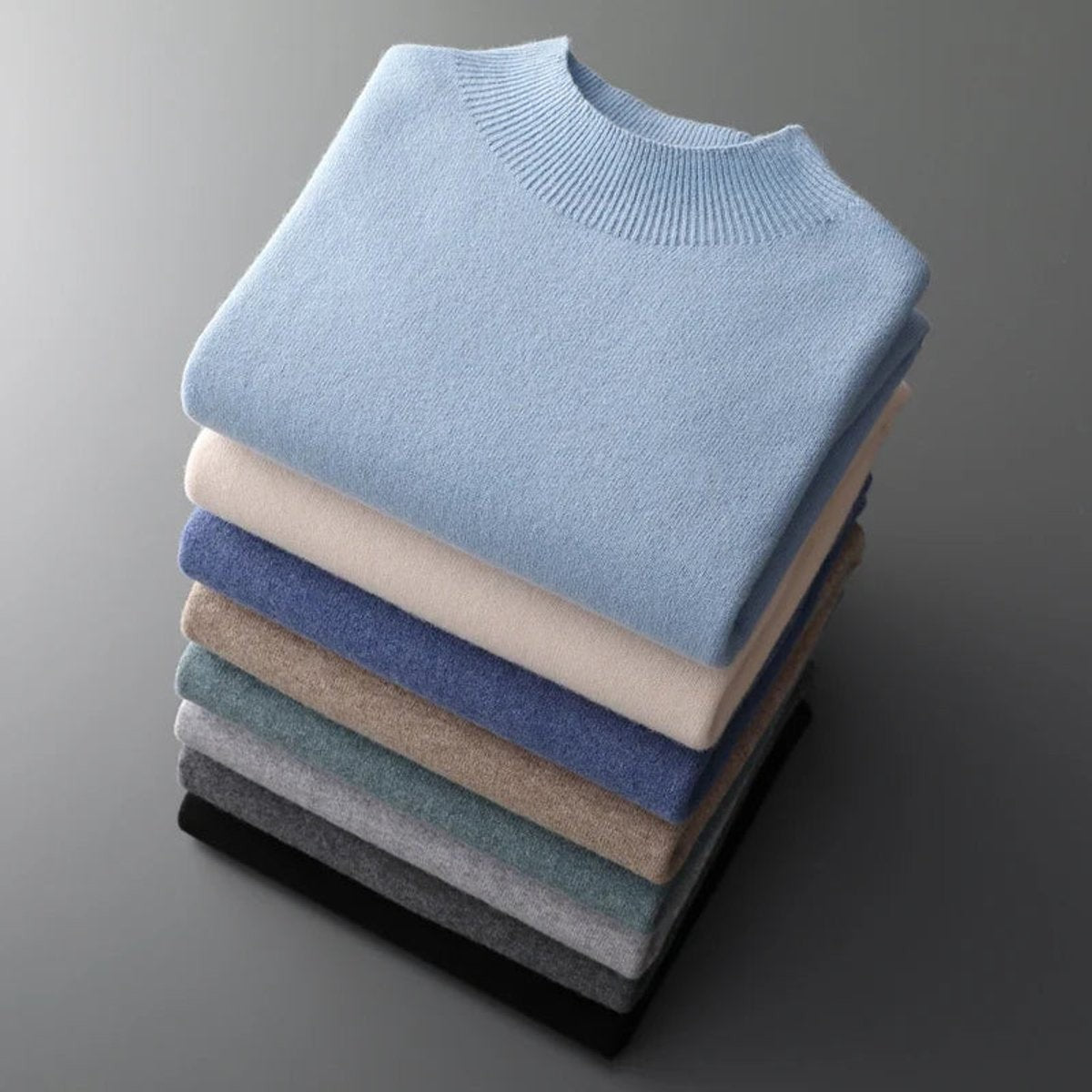 Stack of folded half-neck jumpers in assorted colours showing ribbed collar knit detail