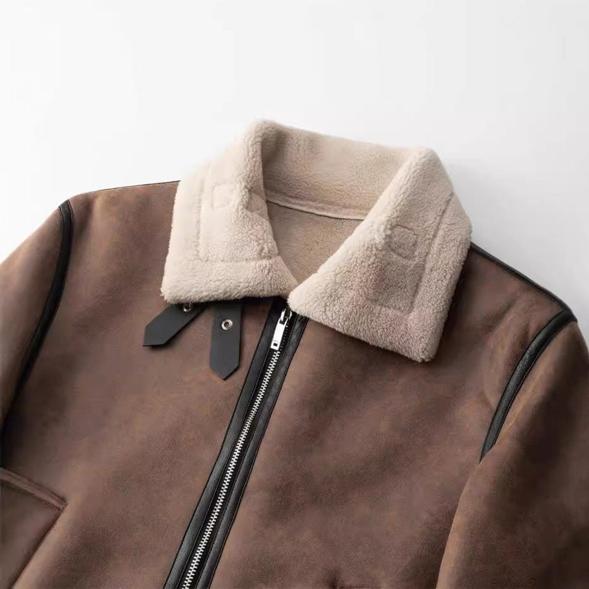Close-up of tan fleece collar on brown faux leather bomber jacket