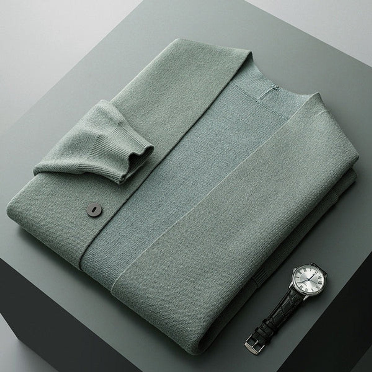 Sage green folded cardigan paired with silver-faced watch on display