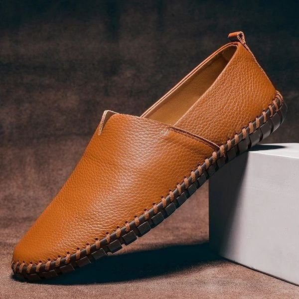 Tan pebbled-grain leather loafers featuring handstitched sole and slip-on style