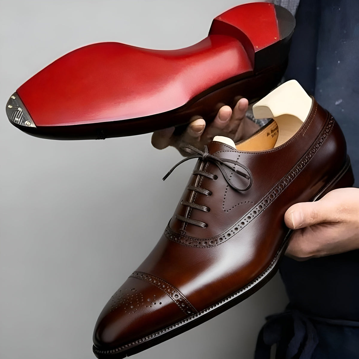 Close-up of brown leather Oxford shoe showing vivid red sole