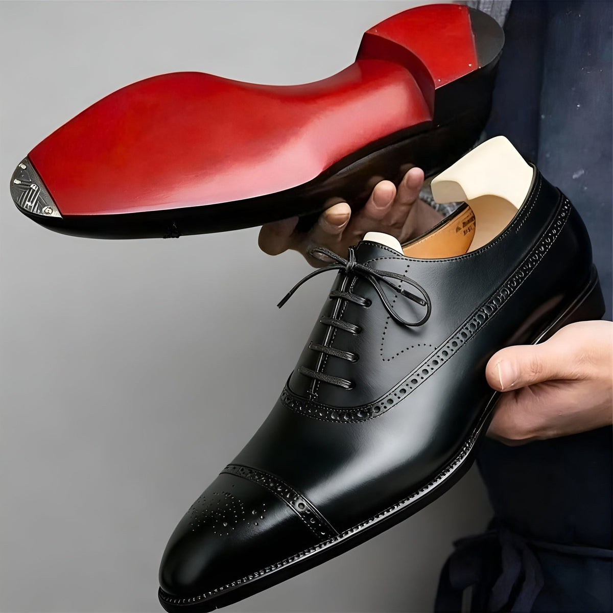 Close-up of black leather Oxford shoe with striking red sole