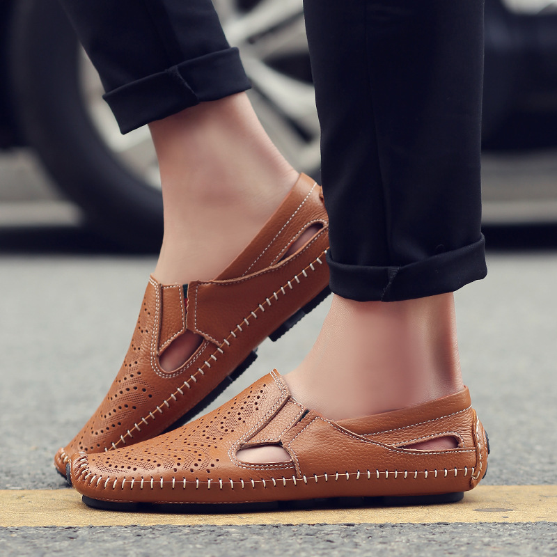 Tan perforated leather sandals worn on foot alongside cropped black jeans