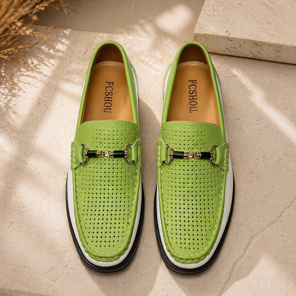 Green perforated leather loafers with white sole shown from above