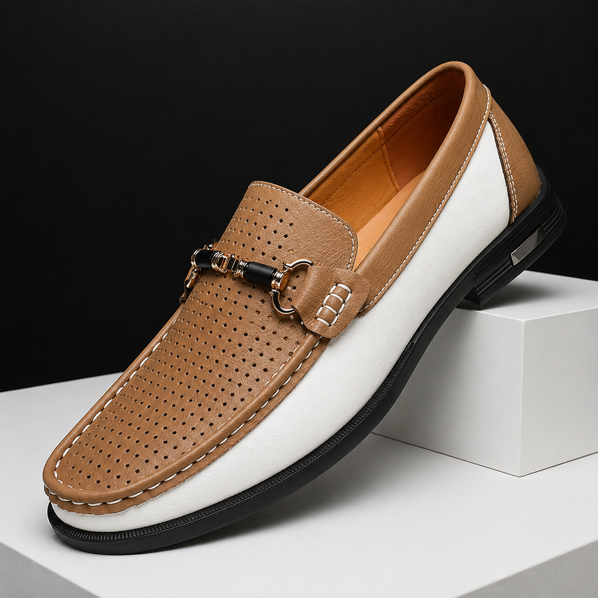 Tan and white two-tone loafers with perforated leather and metal trim