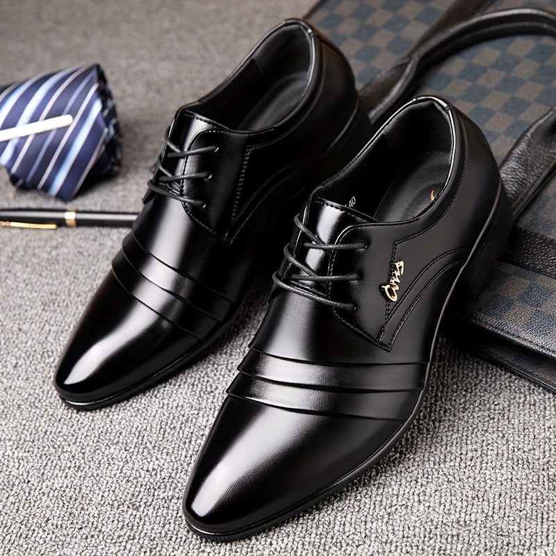 Pair of black lace-up formal shoes beside a striped tie