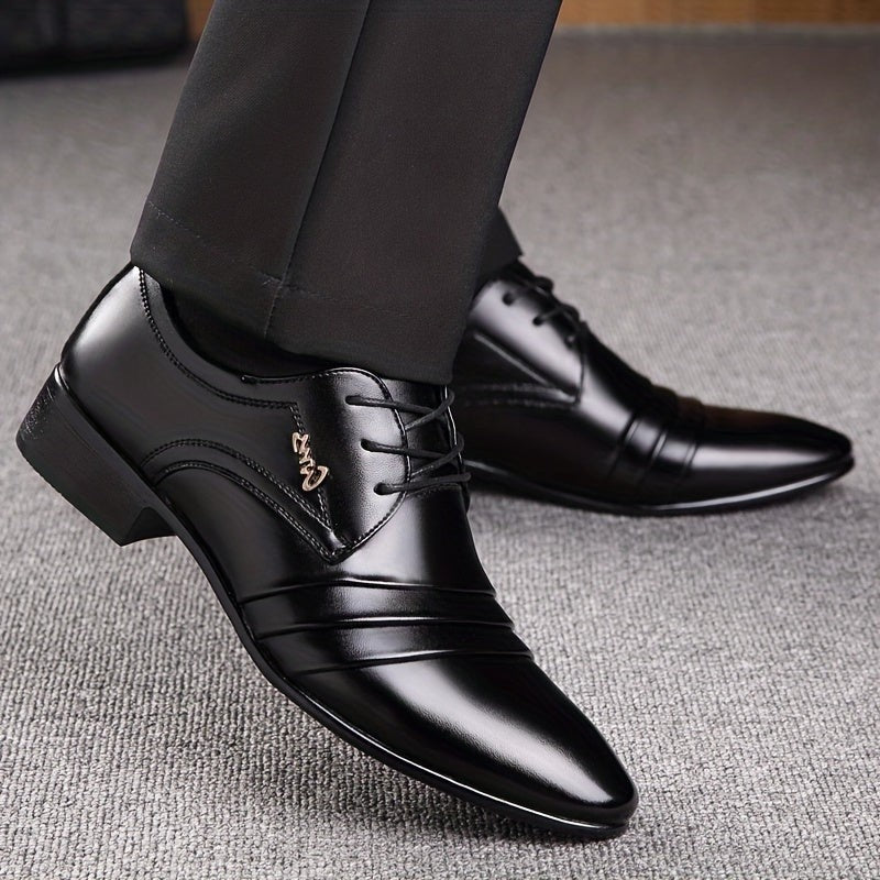 Black lace-up dress shoe with pleated detailing beside vintage books