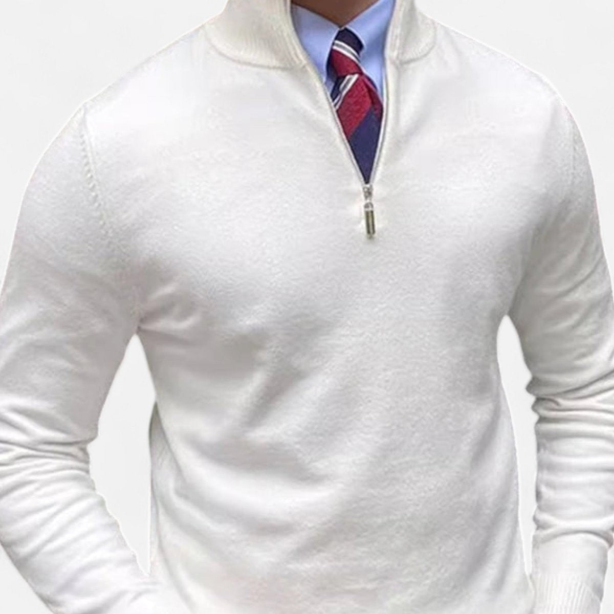 White half-zip knitted jumper worn over blue shirt and striped tie