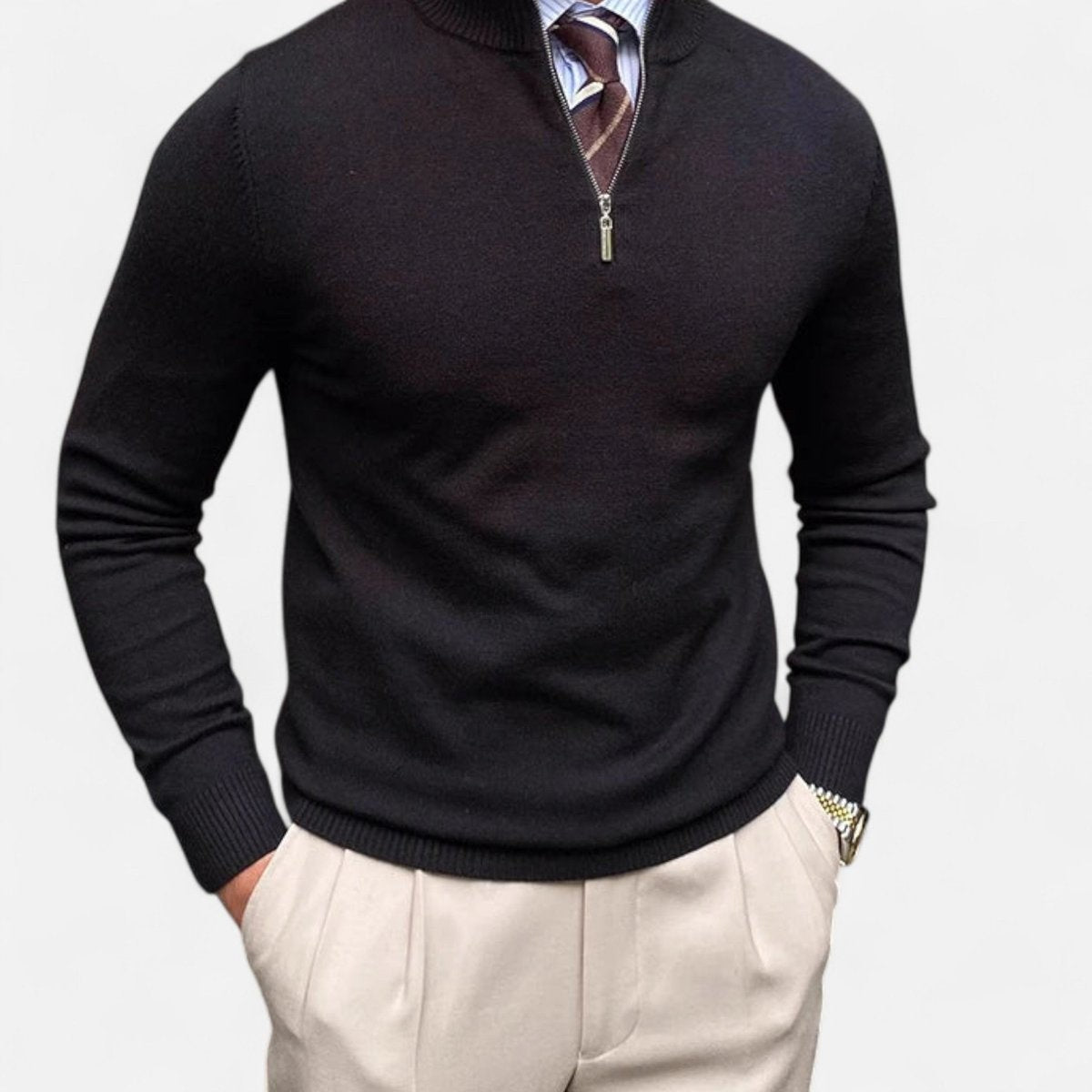 Black quarter-zip jumper styled with striped tie and beige trousers