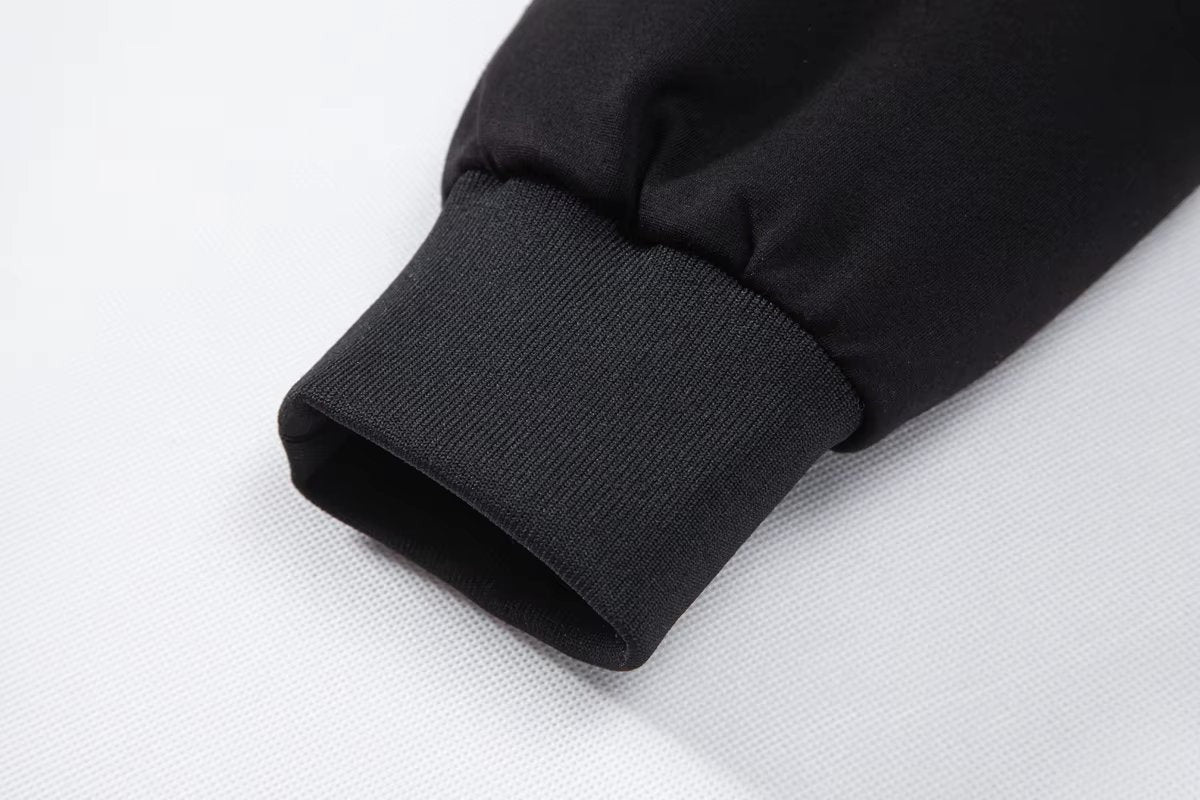 Ribbed cuff detail on black jersey sleeve of hybrid puffer jacket