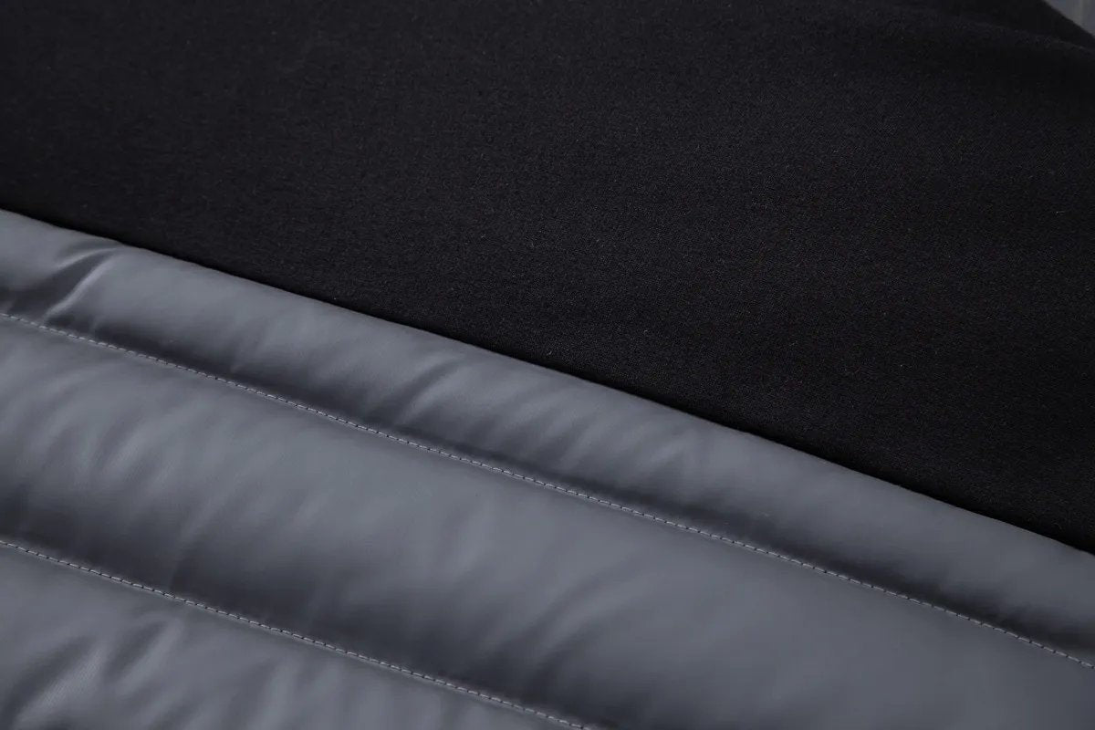 Jersey sleeve cuff seam against grey quilted panel on hybrid jacket